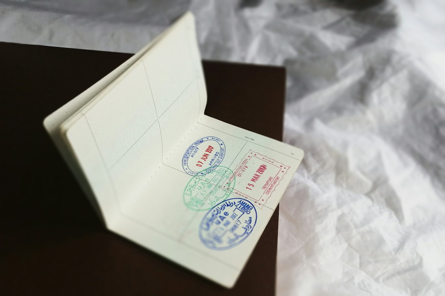 Open passport with colorful international travel stamps.